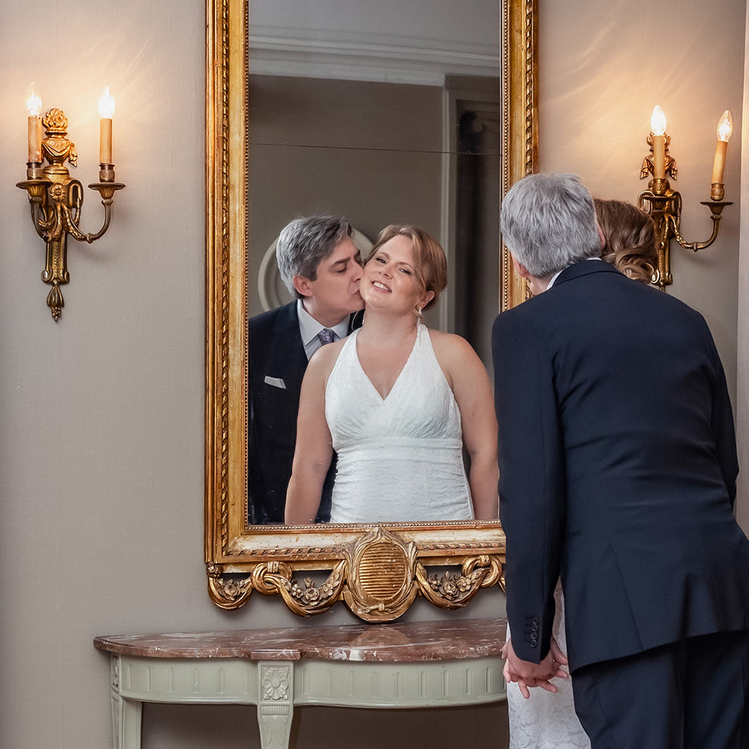 Bröllopspar speglas i spegel med guldram.