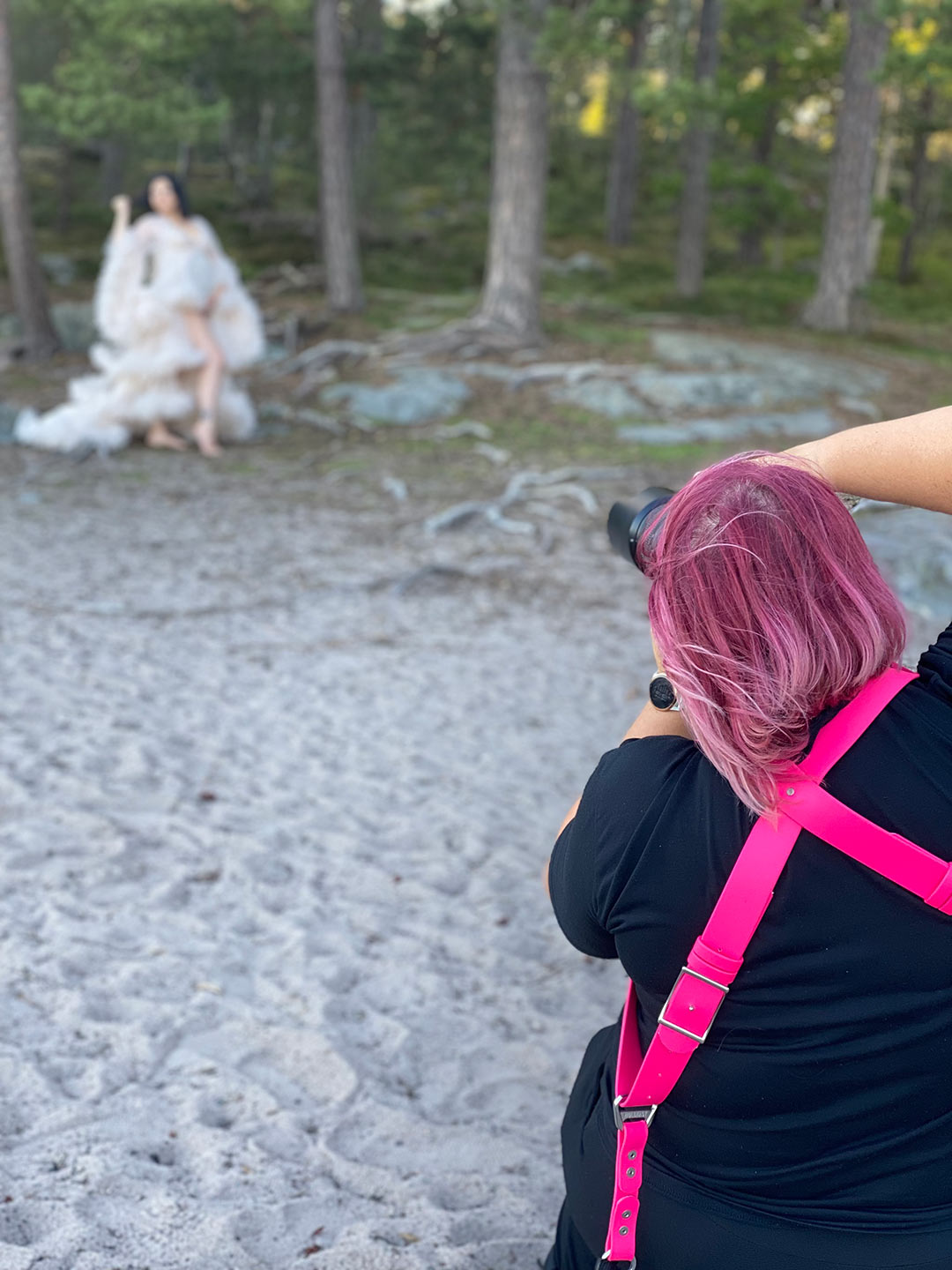 Gravidfotograf Linda Holmkratz fotograferar en gravid kvinna i skogen vid en strand. Bilden är tagen av den blivande pappan.