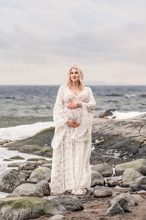 En vacker kvinna under en gravidfotografering i skärgården.