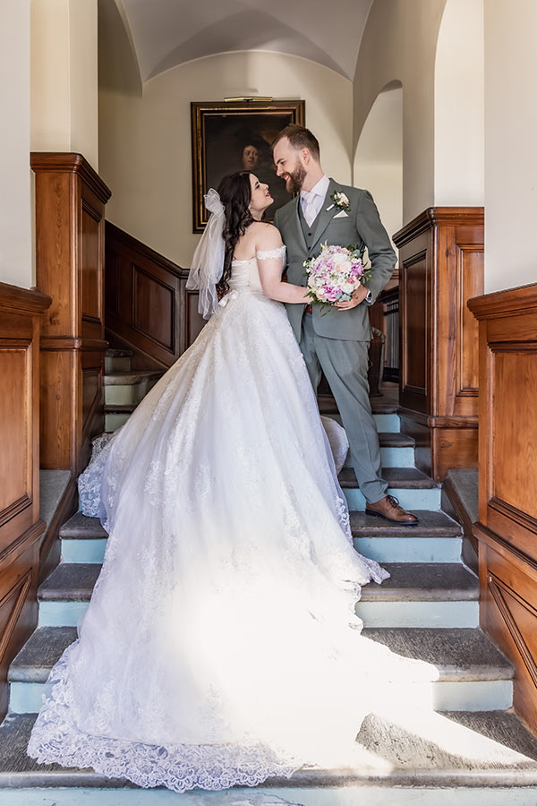 Bröllopsfotograf fotograferar bröllopspar i slottstrappa i Södertuna Slott.